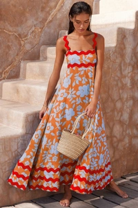 Detail of floral maxi dress with red scalloped trim and summery orange flower print