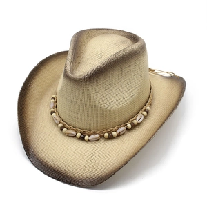 Detail of western straw cowboy hat with woven beads and natural shells decoration