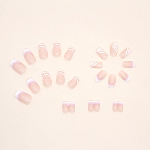 Sweet nude pink press-on nails with white French tips and geometric gradient patterns
