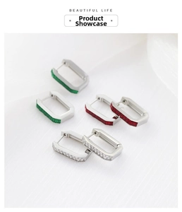 Detailed macro view of silver rectangle hoop earrings with red, green, and clear zircon stones
