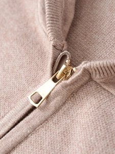 Detailed close-up of metallic zipper and thick knit texture on the oatmeal sweater