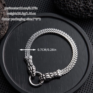 Detailed view of silver snake head bracelet with size specs on black stone surface
