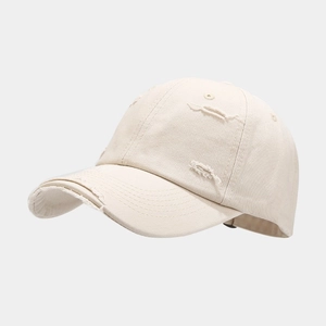 Close-up of distressed cotton twill baseball cap with vintage frayed holes and stitching