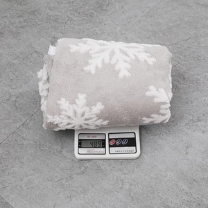 Vue détaillée du tapis de sapin de Noël gris à flocons pesant 489g sur une balance