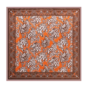 Orange paisley silk square scarf with classic bohemian pattern on a flat surface