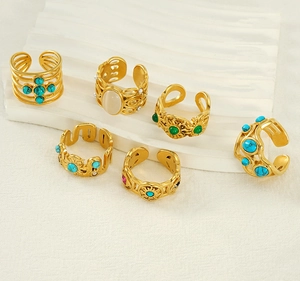 Set of six adjustable gold rings with green malachite and opal stones on a white background