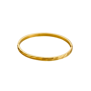 Detailed macro view of golden stainless steel bracelet with textured diagonal engraving