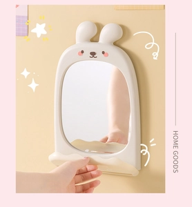 Detail view of beige rabbit wall mirror showing a bottom shelf and cartoon wall decor