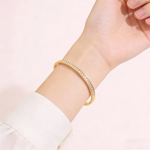 Close-up of elegant gold-plated stainless steel bracelet with sparkling zircons on wrist
