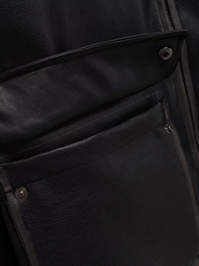 Close-up of side pocket and metal snap button details on black faux leather motorcycle jacket
