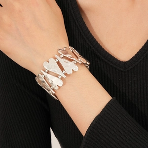 Détail du bracelet élastique en argent vieilli avec pièces métalliques en forme de cœur