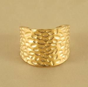 Close-up of 18K gold-plated wide ring showing detailed hammer texture and metallic finish