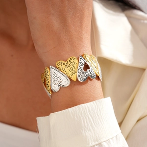 Gros plan du bracelet cœur bicolore avec gravure Laugh Live Love en or et argent poli