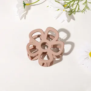 Detail shot of matte flower hair claw clip in soft nude pink with floral decor