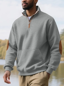Detail eines grauen Sweatshirts mit Waffelstruktur und braunen Ellbogen-Patches