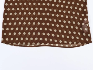 Détail du tissu en mousseline à pois avec étiquette de lavage en 100% polyester