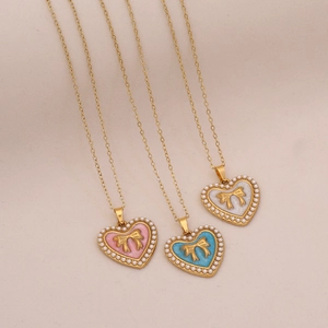Vintage heart necklaces with faux pearls, gold bows, and colorful enamel pendants