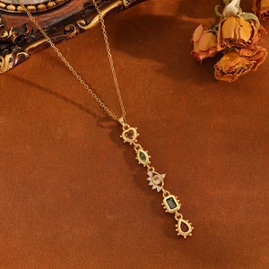 Gros plan sur un collier doré avec des breloques en pierres précieuses multicolores