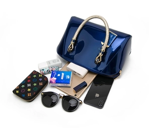 Detail of spacious interior for navy blue patent leather handbag with accessories