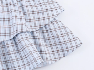Close-up of blue and brown plaid fabric showing layered ruffles and woven texture