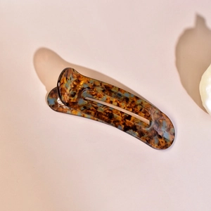 Close-up of elegant tortoiseshell hair claw clip with amber and blue acetate marble finish