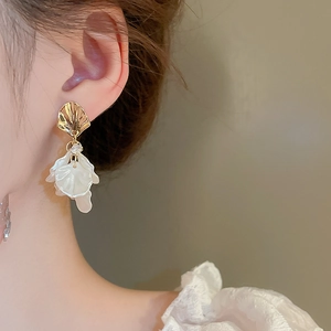 Close-up of elegant acrylic flower petal earrings with gold metal and zircon detail