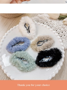 Close-up of five colorful plush cloud hair clips arranged on a white ceramic plate