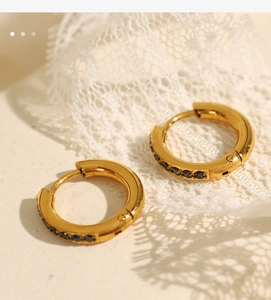 Macro shot of gold-plated hoop earrings featuring micro-paved black zircon stones