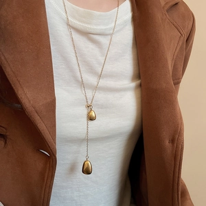 Detail of 18k gold plated Y-shaped necklace featuring two smooth water drop pendants