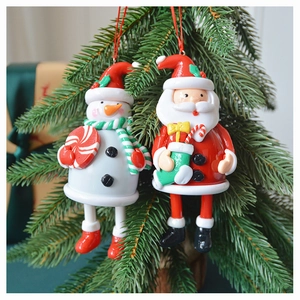 Detailed view of handmade polymer clay Santa and Snowman ornaments on a Christmas tree