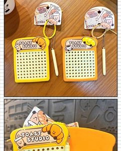 Close-up of toast-shaped magnetic drawing board keychain with 90 beads for stress relief.