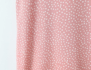 Detailed close-up of pink polka dot fabric texture with soft lace lace material