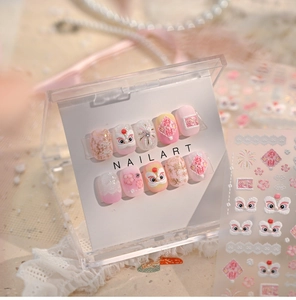 Macro detail of pink lion dance nail stickers with gold floral patterns and lace texture