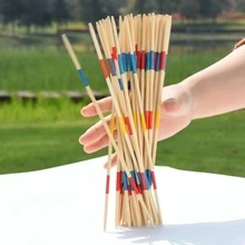Close-up of wooden Mikado pick-up sticks with colorful stripes held outdoors