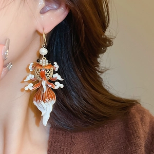 Detail of goldfish drop earrings with orange enamel and pearls worn by a model