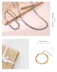 Detail view of gold coffee bean chain necklace and bracelet on stone surface