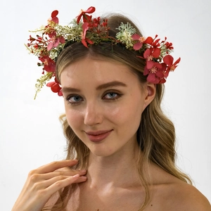 Detail view of handmade floral crown with red and green fabric roses on a model