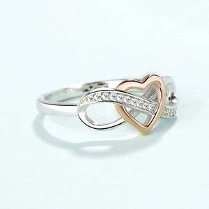 Close-up of S925 sterling silver infinity heart ring with pavé diamonds and two-tone finish