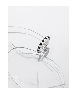 Macro detail of S925 sterling silver ring with black enamel dots on reflective surface