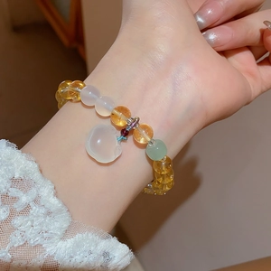 Detail of white chalcedony and citrine beaded bracelet with a jade rabbit charm on wrist