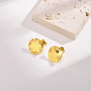Detail view of gold irregular curved stud earrings with a brushed metal matte texture