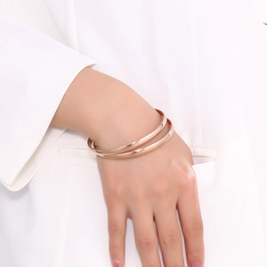 Detail of minimalist double-row rose gold titanium bracelet on woman wrist