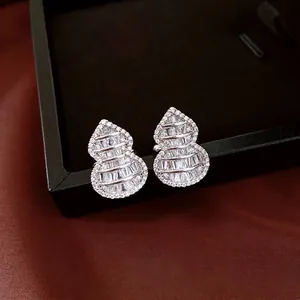 Elegant silver gourd earrings with pavé cubic zirconia set on a black jewelry box