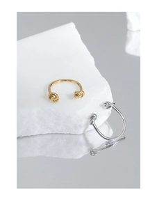 Macro detail of minimalist knotted S925 sterling silver open rings in gold and silver