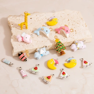 Macro shot of colorful enamel alloy charms featuring giraffe and dolphin for DIY jewelry