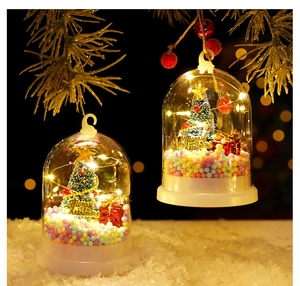 Detail of Christmas tree glass dome lamp with mini gift boxes and warm LED string lights