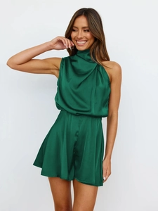 Detailed view of the emerald green satin halter neck romper showing the glossy fabric texture