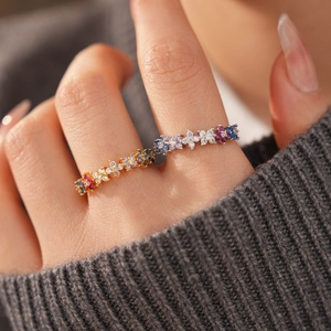 Close-up of 18k gold plated flower ring with colorful zircons on a knitted sleeve