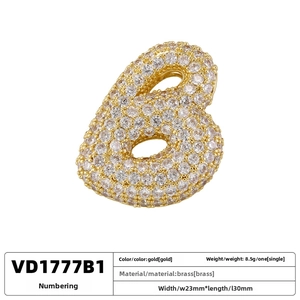 Macro detail of gold plated brass pendant featuring a micro-paved cubic zirconia letter 6