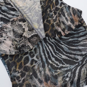 Détail du tissu en maille avec imprimés animaux mixtes et couture du col croisé
